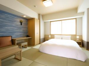 a bedroom with a white bed and a window at Onyado Nono Sendai Natural Hot Spring in Sendai