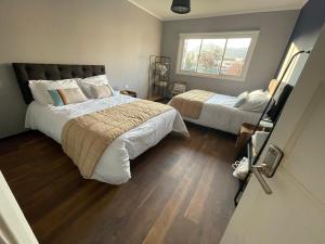 a bedroom with two beds and a window at TQCaleta Providencia Barrio Italia in Santiago