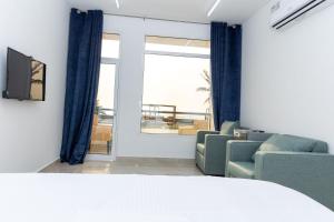 استراحة نادي اورجان Orjan Guest House في Camp: غرفة معيشة مع أريكة وكراسي ونافذة