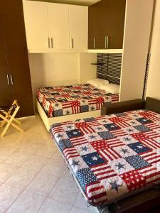 2 Betten in einem Zimmer mit einer Decke darauf in der Unterkunft STOP&GO STATION BOLOGNA house self check-in Stazione AV- FIERA in Bologna