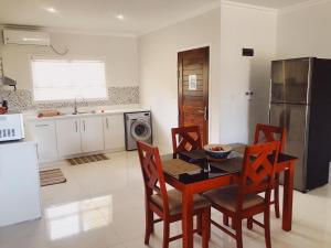 a kitchen with a table and chairs and a refrigerator at Panorama Guesthouse Apartments Beau Vallon Beach in Beau Vallon