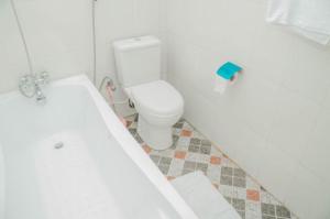 een badkamer met een wit toilet en een bad bij Captivating 1-Bed Studio in Sapele in Sapele