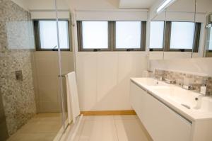 a white bathroom with a sink and a shower at Latitude - with private plunge pool in Rivière Noire