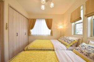 a bedroom with two beds and a window at 舞浜1軒家貸切ー最大10名様一駐車場付きMaihama rent-a-house in Urayasu