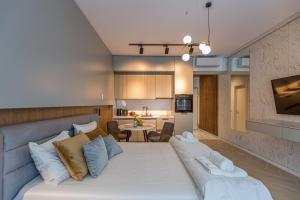a living room with a large bed and a kitchen at Sea On in Mamaia