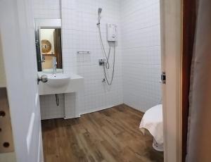 uma casa de banho branca com um chuveiro e um lavatório. em Imm Paknham em Ban Hin Sam Kon