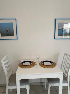 a table with two chairs and a white table with two plates at Apartment Lucia in Pag
