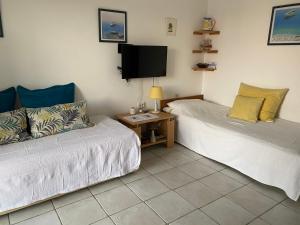 a room with two beds and a tv and a couch at Apartment Lucia in Pag