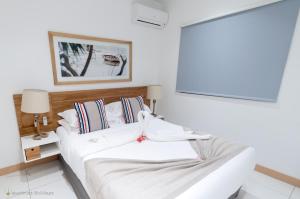 a bedroom with a white bed and a large window at Latitude - with private plunge pool in Rivière Noire