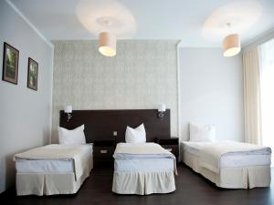 トゥシンにあるHotel Grzegorzewskiのホテルルーム 白いシーツ付きのベッド2台付