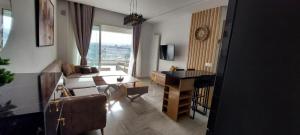 uma sala de estar com um sofá e uma secretária em Horizon Appartment - Hammamet Nord em Hammamet Nord