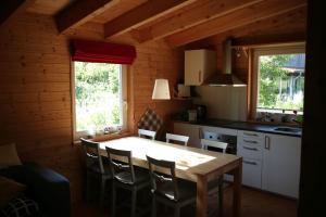 a kitchen with a table and chairs in a cabin at RechHof Urlaub bei Tieren in Schalkenbach