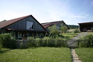 una casa con una valla delante de un patio en RechHof Urlaub mit Tieren en Schalkenbach