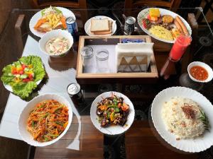 a wooden table with plates of food on it at Hie Moksha Glamping in Kodaikānāl