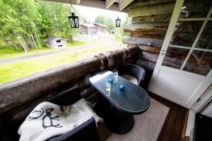 a table and chairs on a porch with a window at Rukankuukkeli b13 in Kuusamo