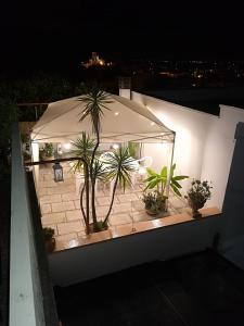 a patio with potted plants and an umbrella at night at vacanza nel salento1 in Matino