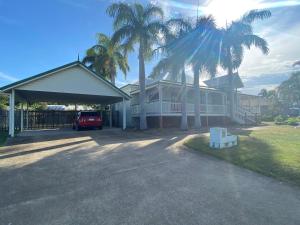 a house with palm trees and a car parked in the driveway at Townsville Home on River Park Drive, Annandale in Townsville
