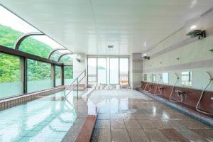 un ampio bagno con piscina con finestre di MolinHotels201 -Sapporo Onsen Story- 1L2Room S-Bed8 8persons a Jozankei