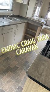 a kitchen with a sink and a counter top at EMDMC Craig Tara Caravan in Ayr