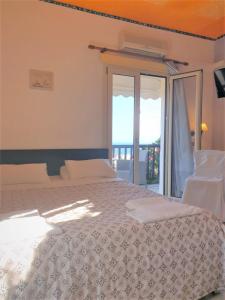 a bedroom with a bed and a sliding glass door at Private Studio Korifi sea view in Hersonissos
