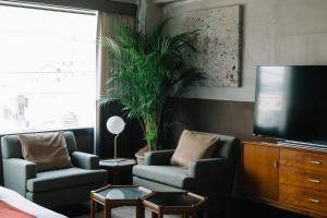 a hotel room with two chairs and a tv at HOTEL Inc in Kyoto