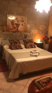 Un dormitorio con una cama grande con una pared de piedra. en Domus de Janas Rooms Gonnesa, en Gonnesa