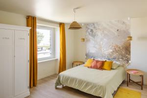 1 dormitorio con 1 cama con una pintura en la pared en o DEGEMER MAT o COTE MER o TRES BELLE VUE MER o, en Saint-Benoît-des-Ondes