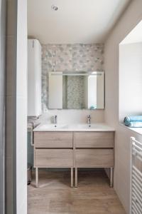 bagno con lavandino e specchio di Degemer Mat - Côté Mer - Très belle vue mer a Saint-Benoît-des-Ondes