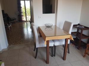 - une table à manger avec des chaises blanches et une table en bois dans l'établissement Filippos Apartments "Apartment 1", à Céphalonie