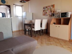 a kitchen with a table and white chairs in a room at Filippos Apartments "Apartment 2" in Spartià