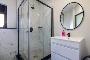 y baño con ducha, lavabo y espejo. en Lovely 1 Modern bedroom in Waterfall City, en Midrand