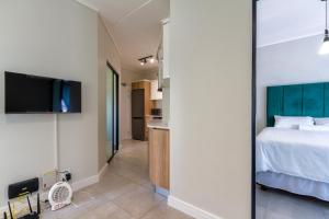 1 dormitorio con 1 cama y TV en la pared en Lovely 1 Modern bedroom in Waterfall City en Midrand