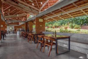 a row of tables and chairs in a restaurant at Estate Stay - Riverside Coffee in Siddapur
