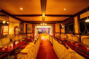 a restaurant with long tables and chairs in a room at Yunoshimakan in Gero