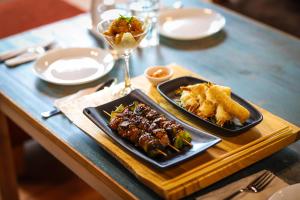 una tavola con due piatti di cibo e un bicchiere di vino di The Little Paradise a Kalimpong