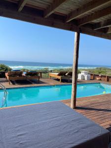 a swimming pool with a view of the ocean at Baleia Azul 14 in Ponta Mamoli