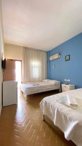 a bedroom with two beds and a blue wall at Saray Hotel in Kas