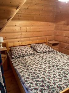 um quarto com uma cama num chalé de madeira em Góralski Apartament em Witów