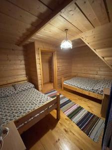 an attic room with two beds in a log cabin at Góralski Apartament in Witów