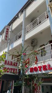 a sign on the side of a building with flowers at Saray Hotel in Kaş