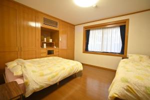 1 dormitorio con 2 camas y ventana en Private Beppu Tanoyu Onsen, en Beppu