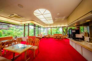 a restaurant with tables and chairs and a red carpet at Yunoshimakan in Gero