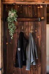 a group of coats hanging on a wooden wall at Suite Sinfonie Bergstille in Grän