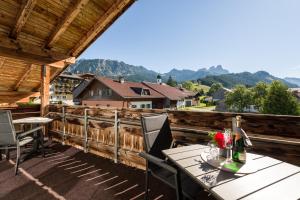 une terrasse en bois avec une table et des chaises. dans l'établissement Suite Sinfonie Bergstille, à Grän