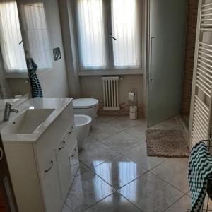 a bathroom with a sink and a toilet and windows at Appartamento GIRASOLE, Salò in Salò