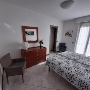 薩羅的住宿－Appartamento GIRASOLE, Salò，一间卧室配有一张床、梳妆台和椅子