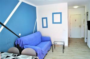 un soggiorno con divano blu e tavolo di Cris Sol Apartments a Los Cristianos