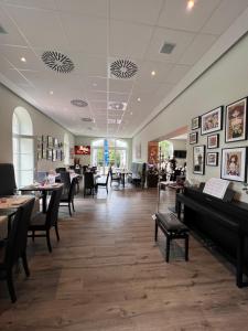 um restaurante com mesas e cadeiras e um piano em Eschberger Hof em Saarbrücken