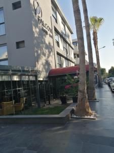 a building with palm trees in front of a street at Falcon 1511 in Antalya