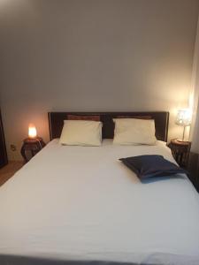 uma grande cama branca com duas almofadas em Apartament Kościuszki em Kielce